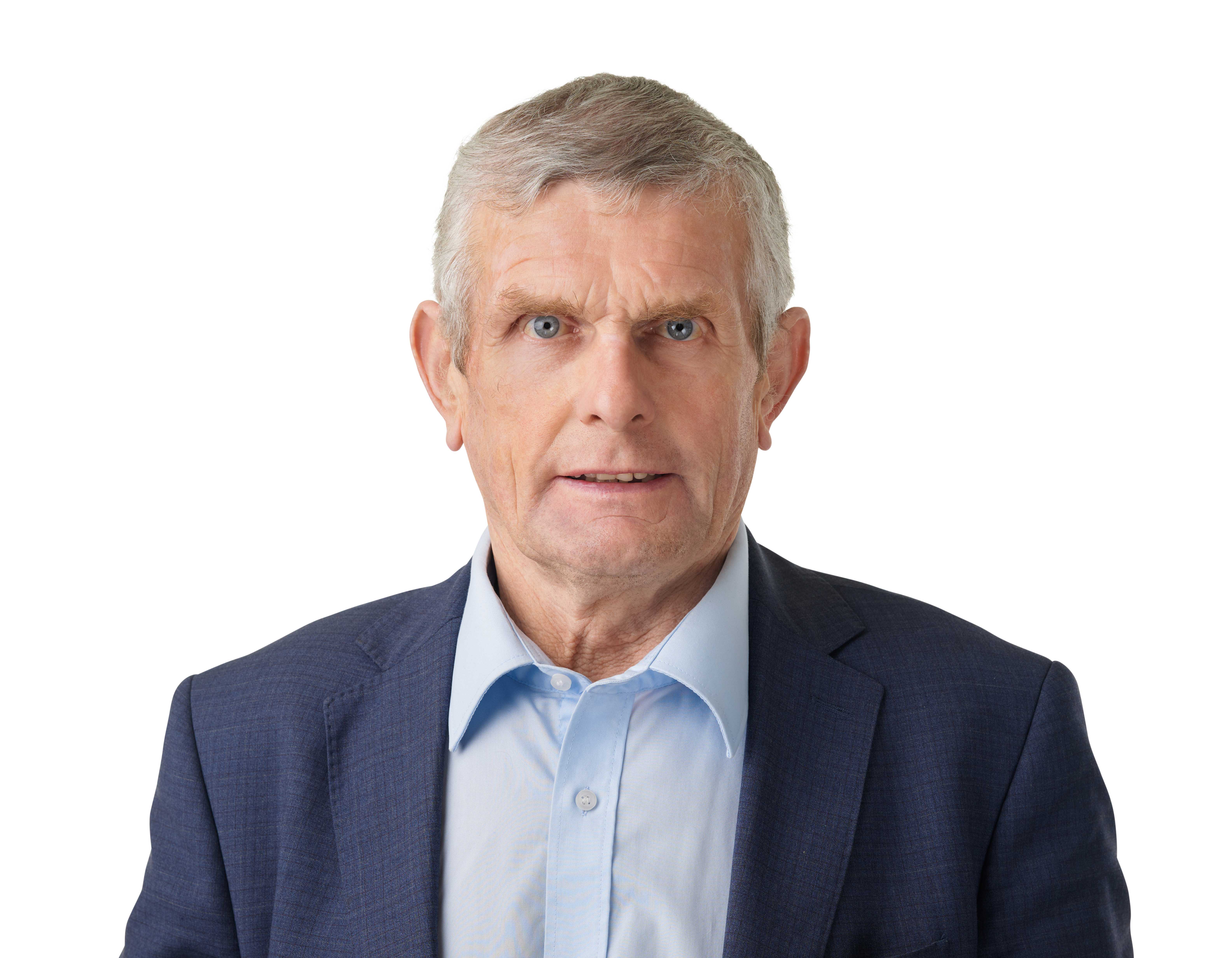 Senior man with gray hair, blue eyes, wearing a blue jacket with an unbuttoned light blue collared shirt.